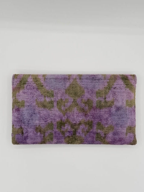 A rectangular area rug with a distressed purple and olive green damask pattern, shown flat against a plain white background.