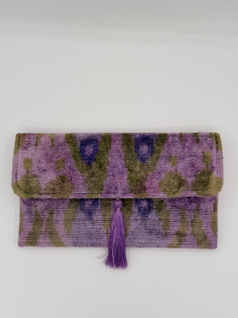 A folded purple and olive green patterned textile item with a matching purple tassel, photographed against a plain light background.