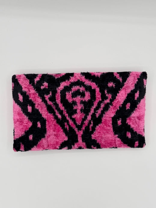 A rectangular pink and black patterned towel or mat with a textured, fuzzy surface, shown against a plain light gray background.
