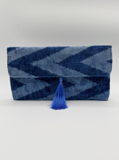A folded blue and navy chevron-patterned woven textile with a bright blue tassel, photographed against a plain light background.