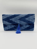 A folded blue and navy chevron-patterned woven textile with a bright blue tassel, photographed against a plain light background.
