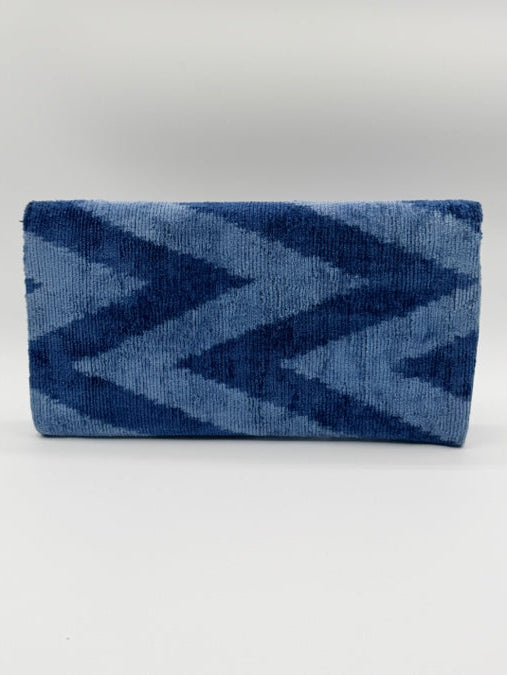 A folded rectangular textile item, likely a towel or blanket, featuring a blue and navy chevron pattern against a plain light background.