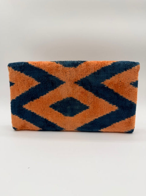 A rectangular woven towel or rug with a bold geometric pattern in orange and dark navy blue, shown against a plain white background.