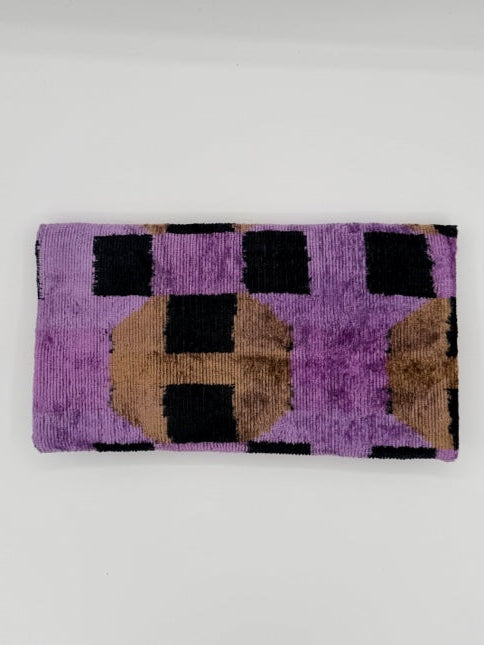 A rectangular woven textile with a geometric pattern in purple, black, and tan, displayed flat against a plain white background.